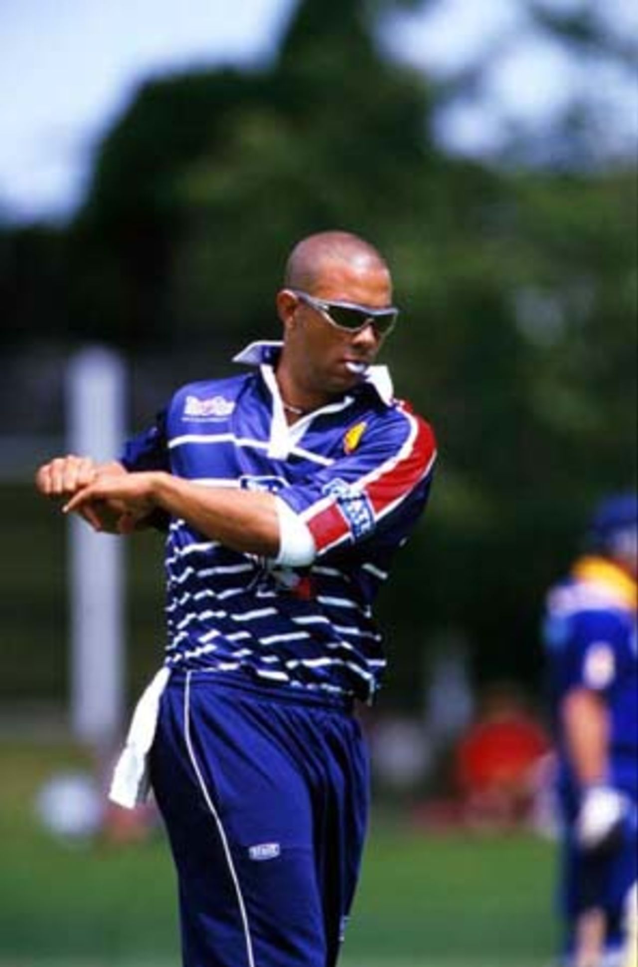 Auckland medium fast bowler Andre Adams does some warm-up stretches before his spell of 1-17 from 10 overs. Shell Cup: Auckland v Otago at Eden Park Outer Oval, Auckland, 17 December 2000.