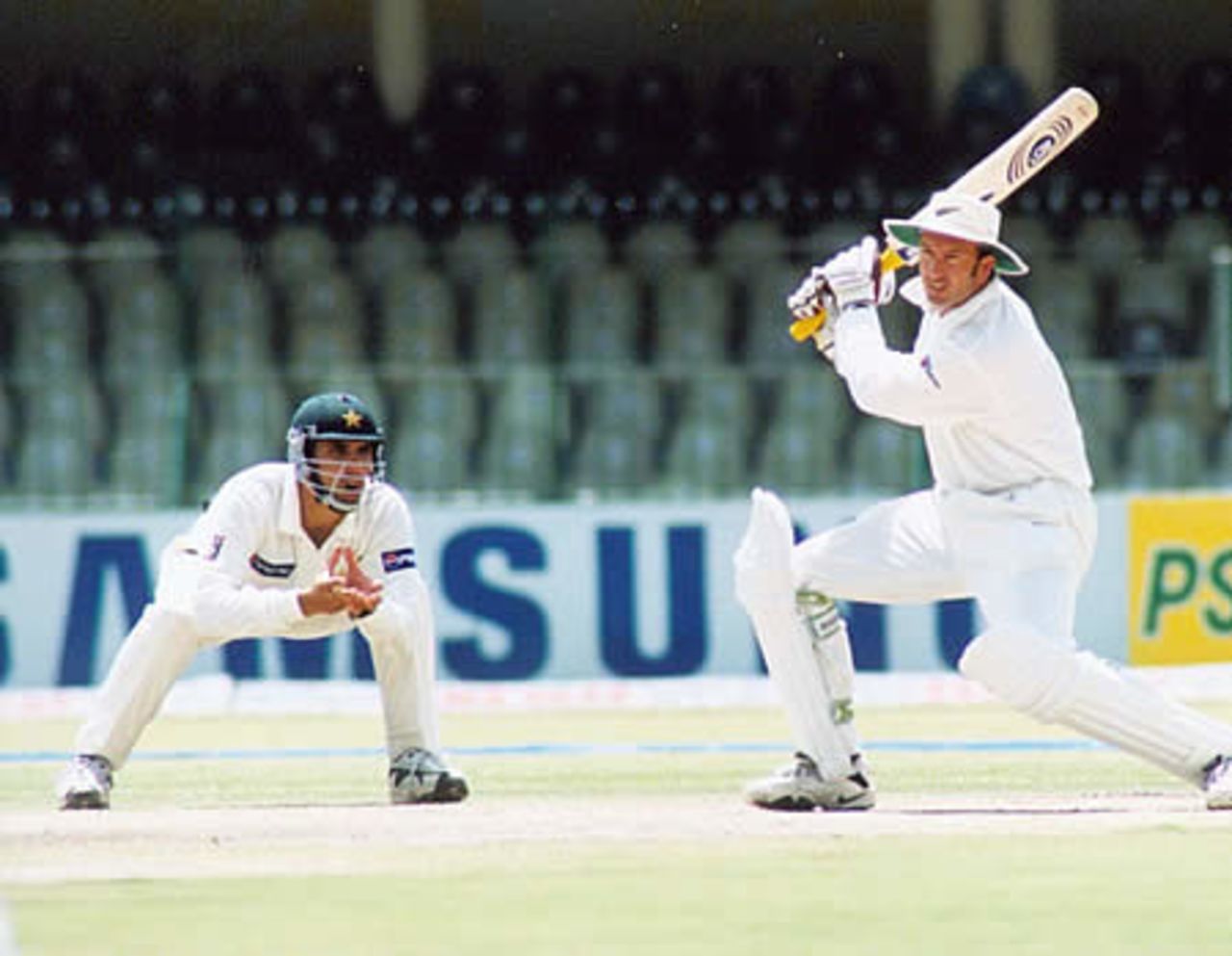 Chris Harris drives into the covers as Abdul Razzaq looks on - New Zealand second innings, day 3, 1st Test, New Zealand v Pakistan, Gaddafi Stadium Lahore, 3 May 2002