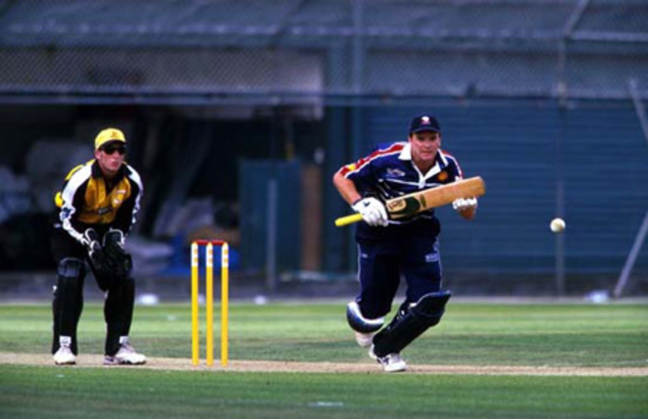 Auckland batsman Dion Nash drives down the ground during his innings of 19 while Wellington wicket-keeper Chris Nevin looks on. Shell Cup: Auckland v Wellington at Eden Park Outer Oval, Auckland, 27 December 2000.