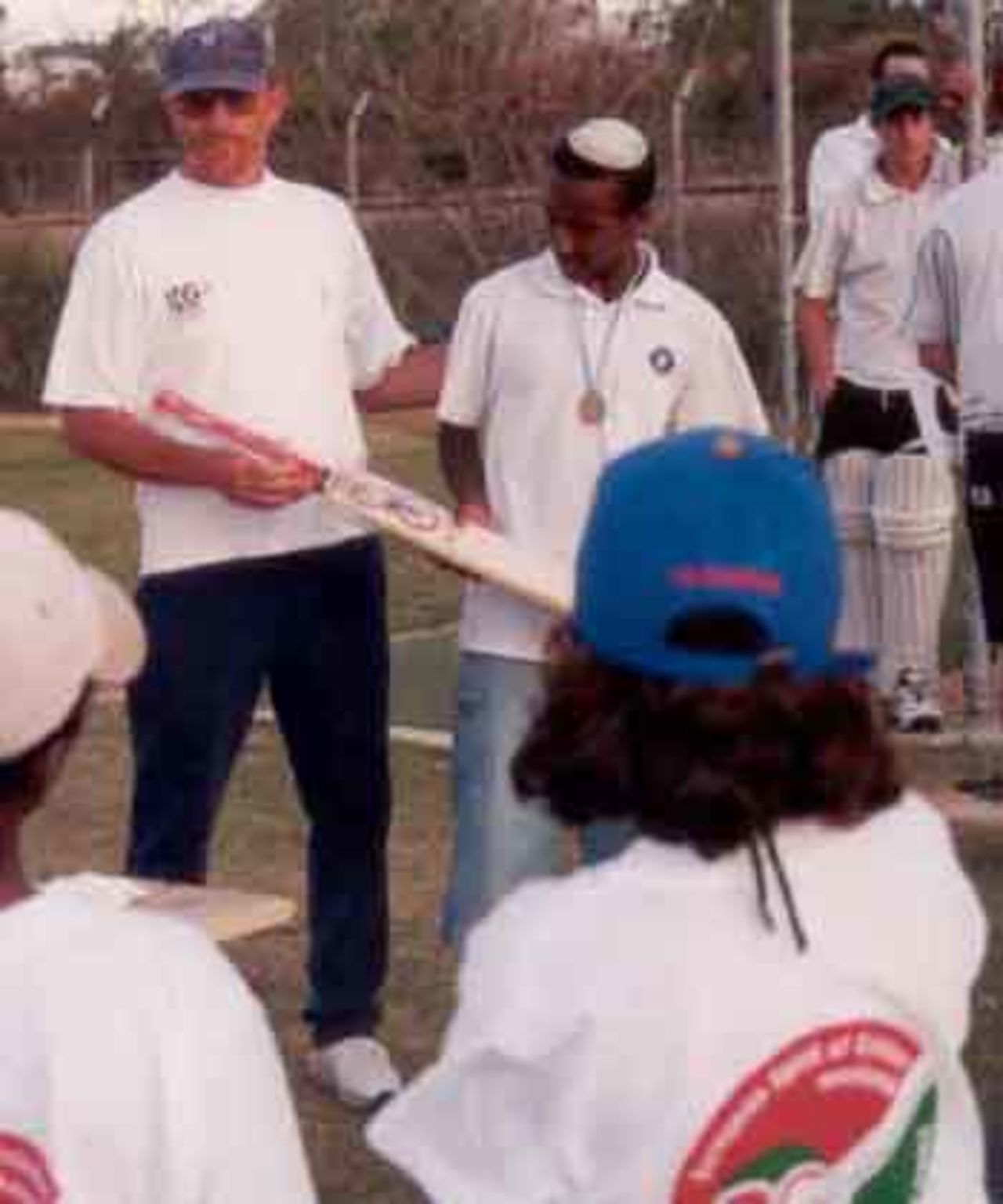 Michael Muchie receives his bat from ICA Youth Director George Sheader having won the bowling competition