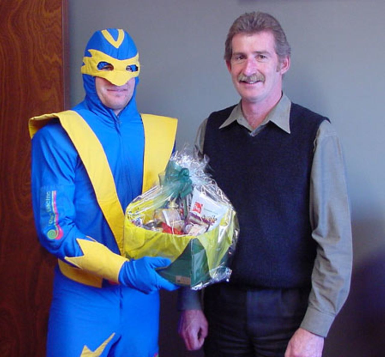 How's this for a birthday surprise? Otago Cricket's mascot, Voltman, stuns OCA board member Murray Hughes with the presentation of a gift basket on his 50th birthday. Murray is managing director of one of New Zealand's largest electrical firms Aotea Electric, which is also a major sponsor of Otago Cricket. 17 May 2002.