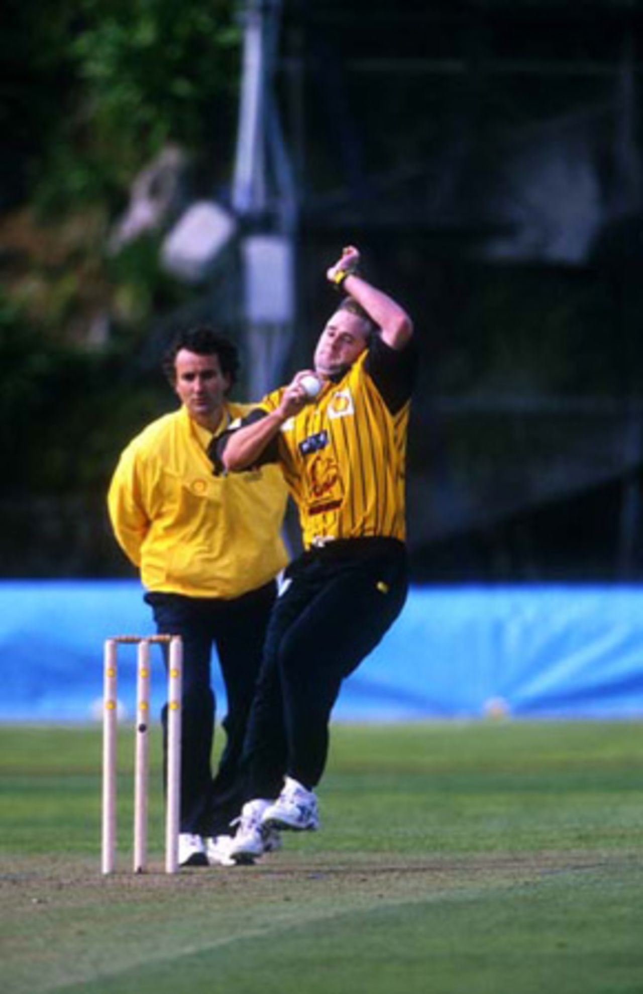 Wellington bowler Paul Hitchcock delivers a ball during his spell of 1-41 from 10 overs. Umpire Brent Bowden looks on. Shell Cup: Auckland v Wellington at Eden Park Outer Oval, Auckland, 27 December 2000.