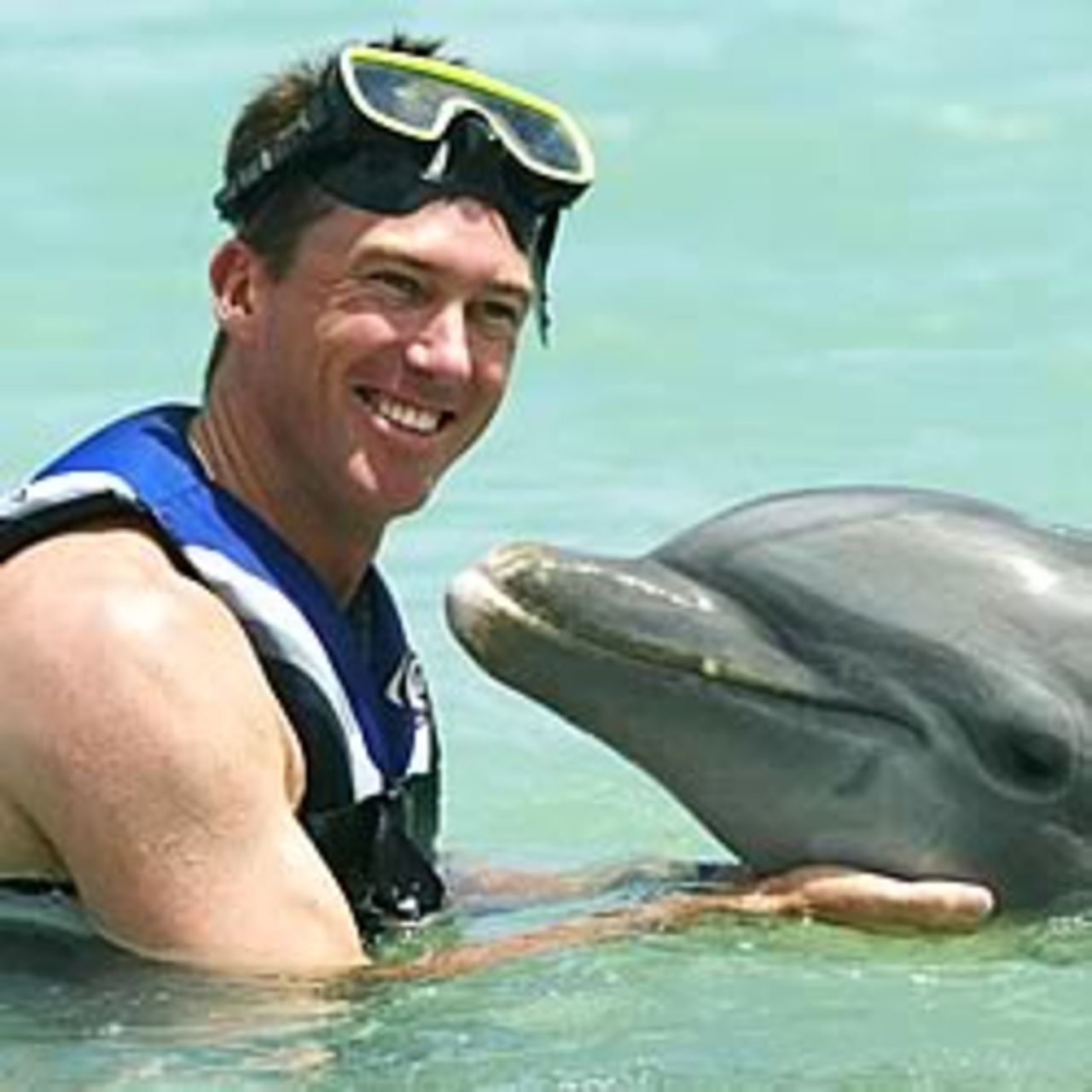 ST JOHN'S, ANTIGUA - MAY 8: Glenn McGrath of Australia plays in the water with a dolphin during a team visit to Dolphin Fantaseas on May 8, 2003 in St John's, Antigua.