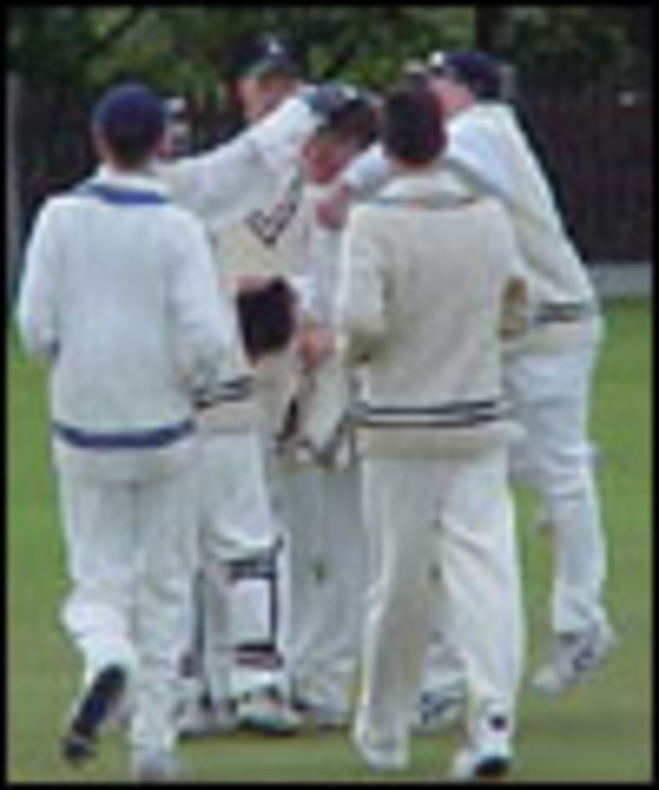 Andrew Bentley is mobbed by his team-mates after taking his fifth wicket for Church against East Lancs