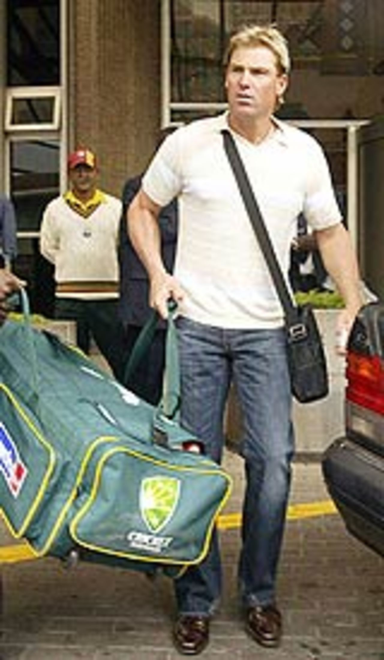 Shane Warne loads his bags into a car