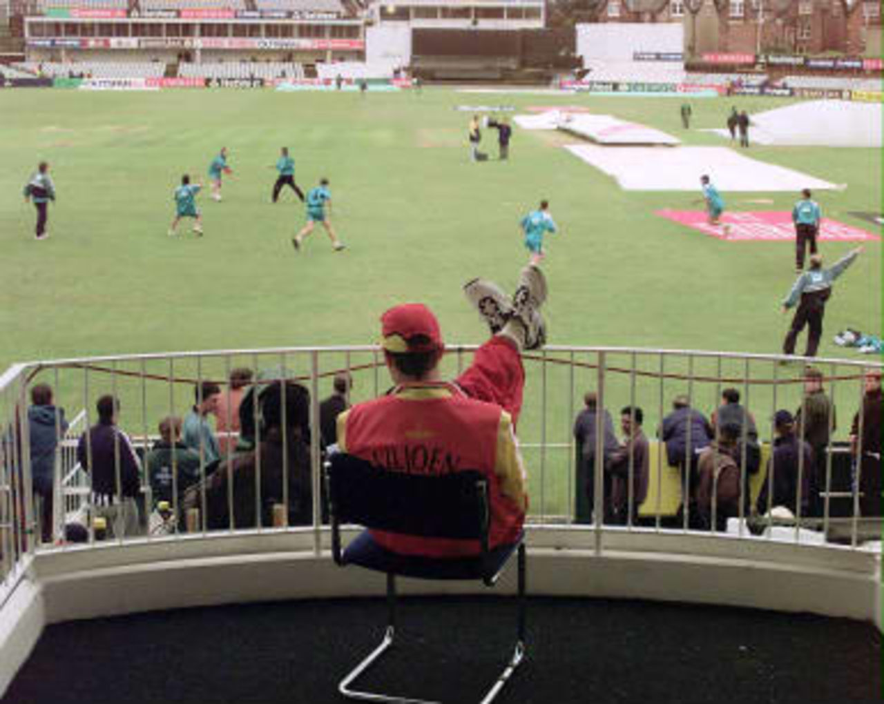 The New Zealand team plays frisbee on the field while Dirk Viljoen of Zimbabwe watches from the balcony as the Zimbabwe v New Zealand Cricket World Cup Super Six match was rained off again at Headingley for the second day in a row.