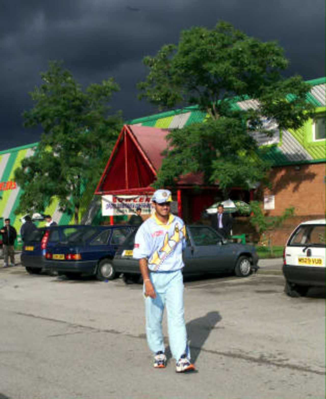 India's opening batsman Saurav Ganguly limps to the team coach after injuring his right leg, as storm clouds gather over Manchester.