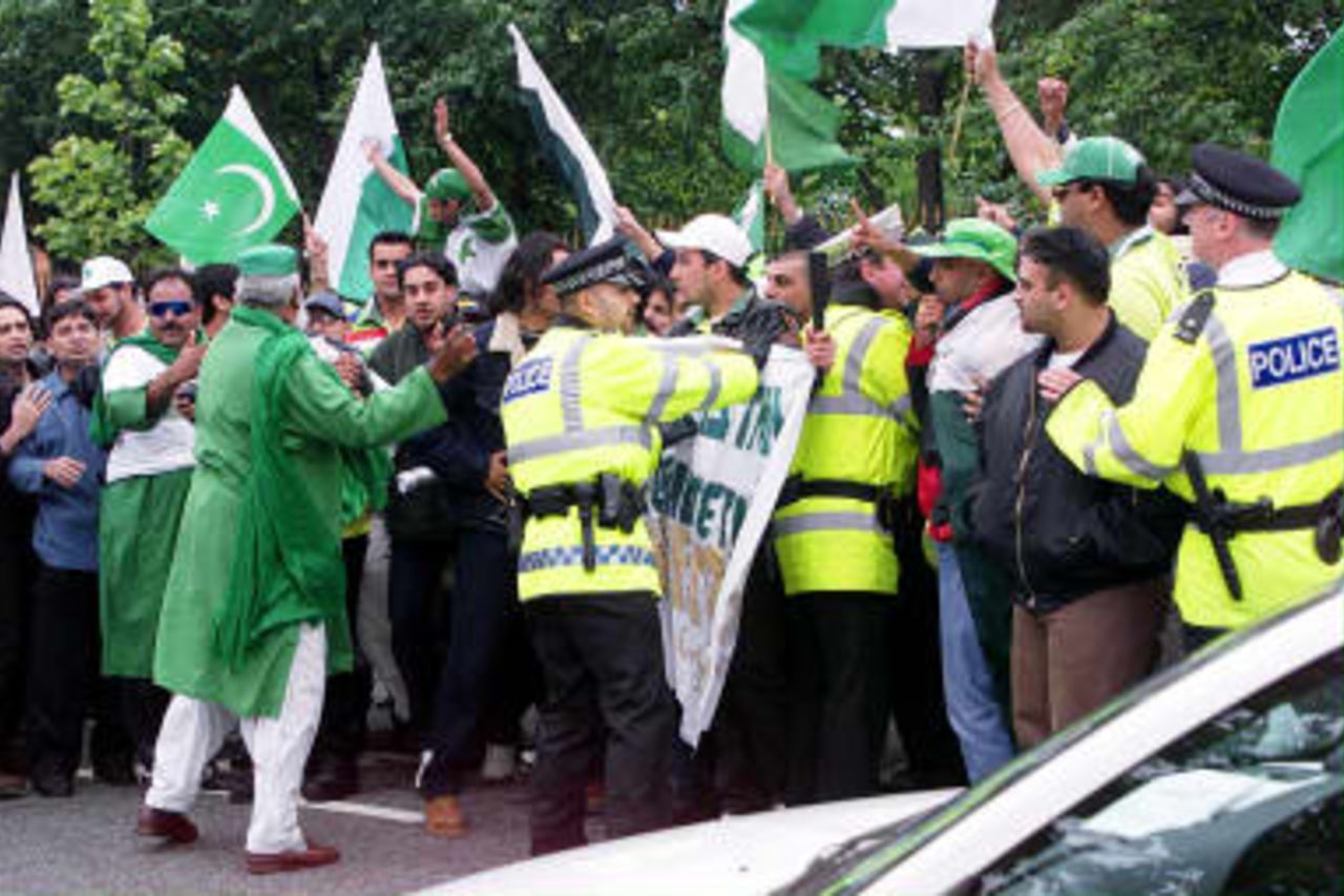 Enthusiastic Pakistan fans are held back by police after holding up traffic 08 June 1999, before todays Cricket World Cup match against India at Old Trafford, in Manchester