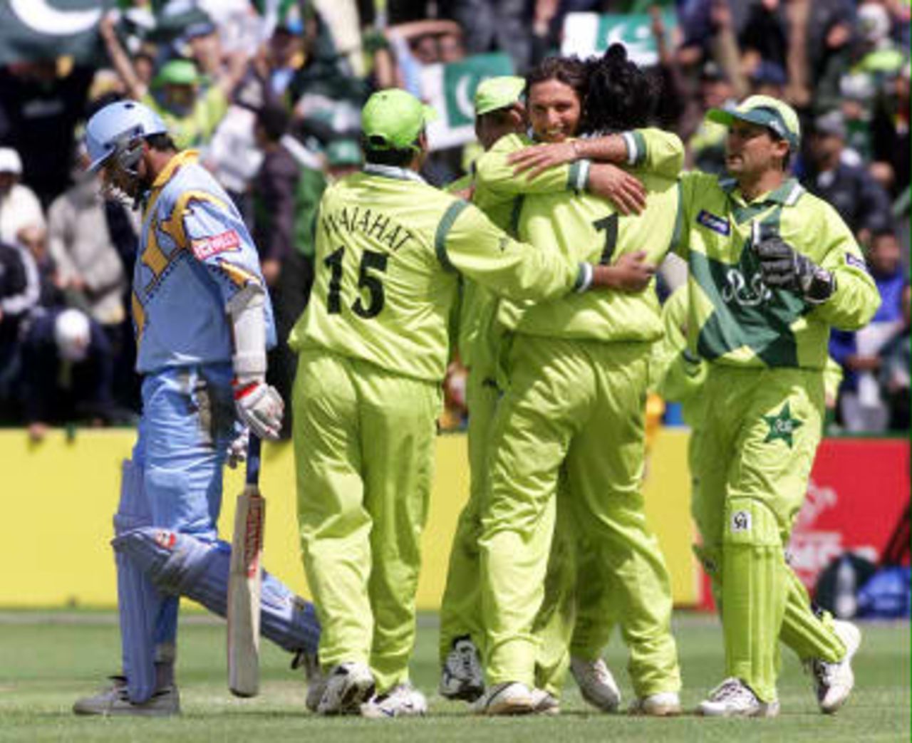 India's Rahul Dravid (L) walks to the pavilion as team mates congratulate Wasim Akram 08 June 99 during their Cricket World Cup match at Old Trafford, Manchester