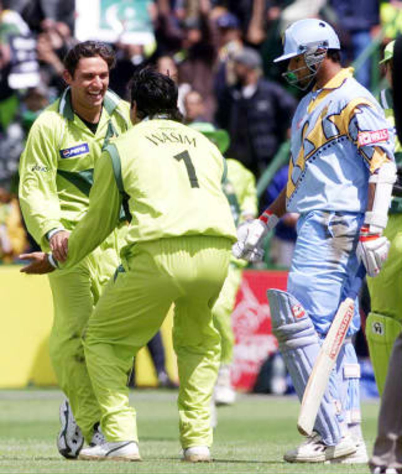 India's Rahul Dravid (R) walks to the pavilion as Pakistan bowler Wasim Akram (C) jubilates with catcher Shahid Afridi 08 June 1999 during their Cricket World Cup match at Old Trafford, Manchester