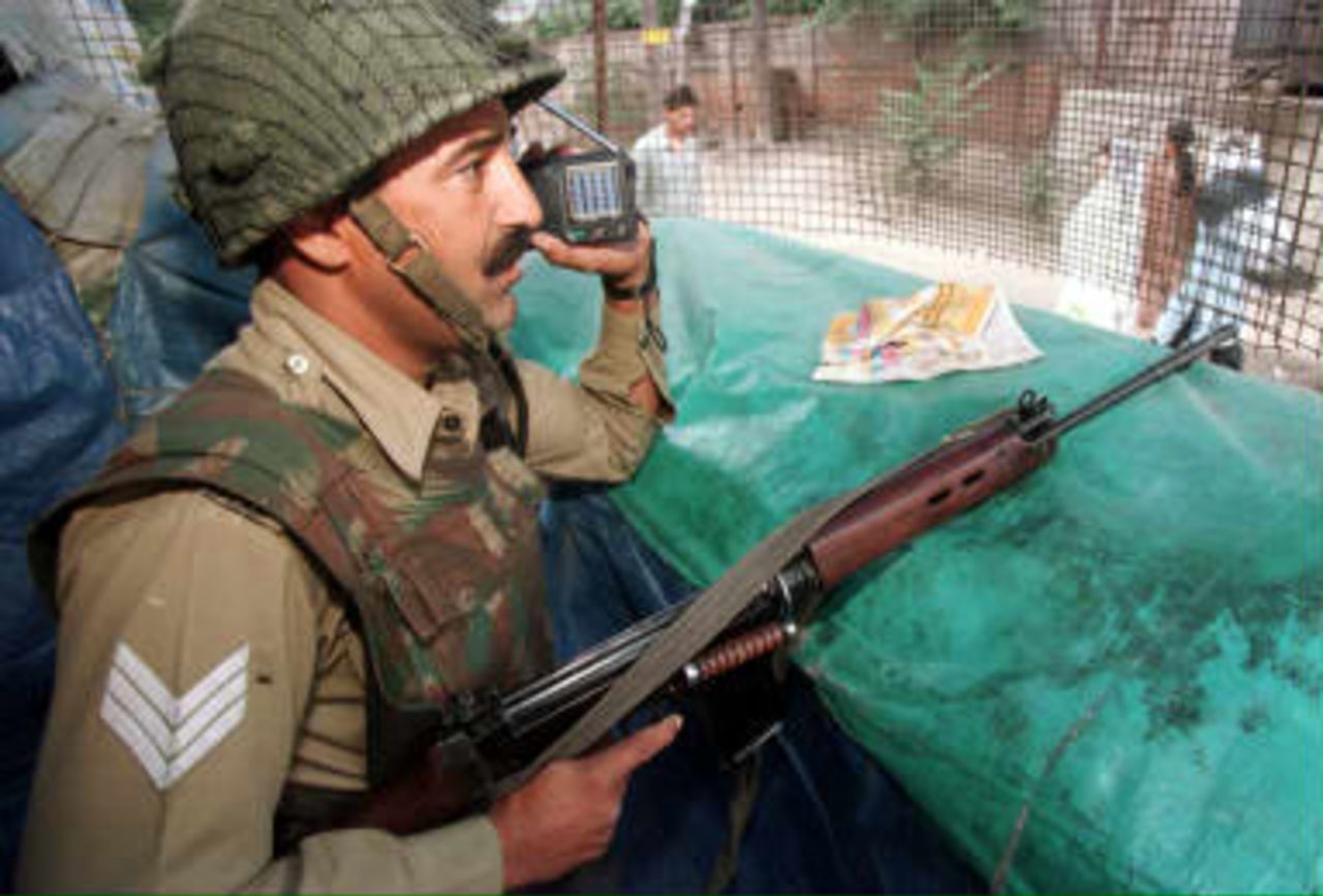 A Border Security Force officer listens to the cricket World Cup match pitting India against Pakistan on a transistor radio as he keeps watch from a bunker 08 June 1999 in Srinagar. Most Kashmiris are rooting for Pakistan, currently involved in cross-border shelling with India, while most of the armed forces present in Kashmir will be rooting for India