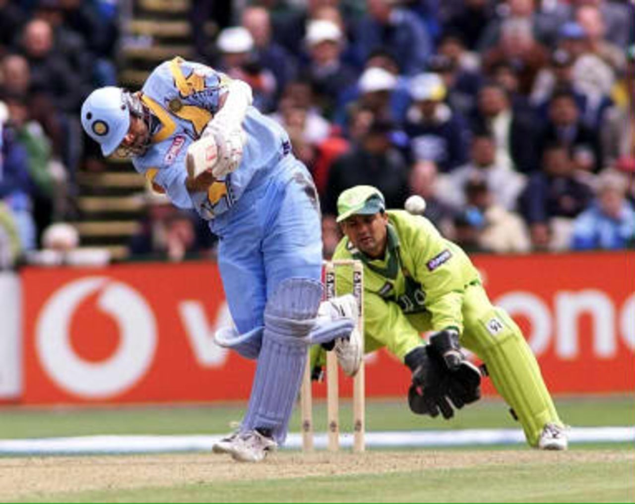 Indian batsman Rahul Dravid flicks the ball from Saqlain to leg as Pakistan keeper Moin Khan looks on during their Cricket World Cup match at Old Trafford in Manchester 08 June 1999.