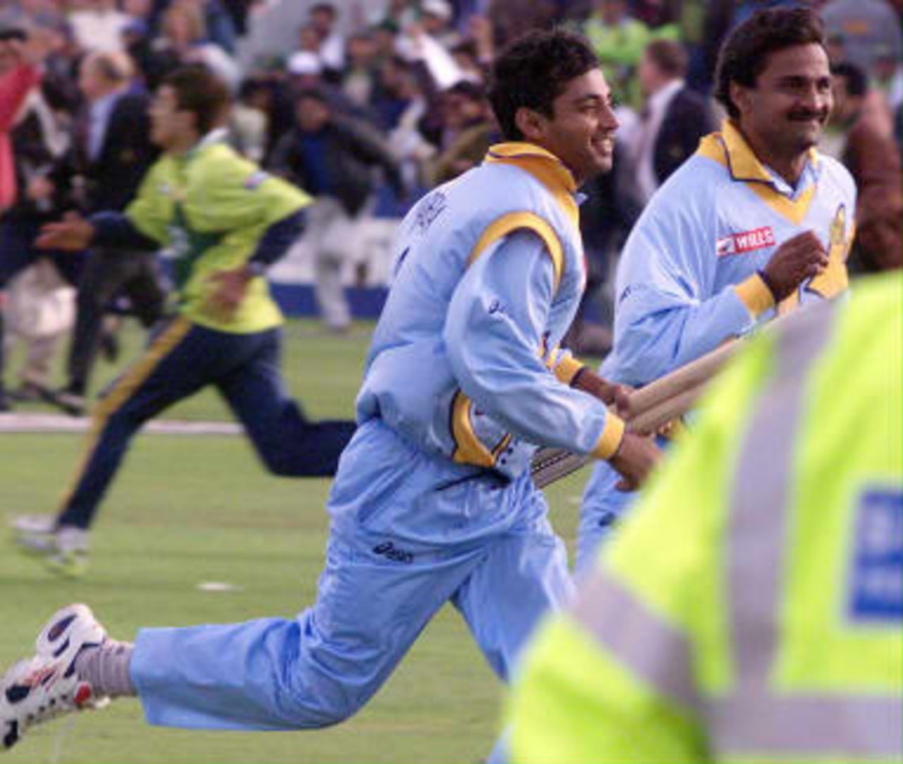 Indian players, Ajay Jadeja and Javagal Srinath run for the protection of the Pavilion at the end of the match against Pakistan in the cricket World Cup series match at Old Trafford. 08 June 1999.