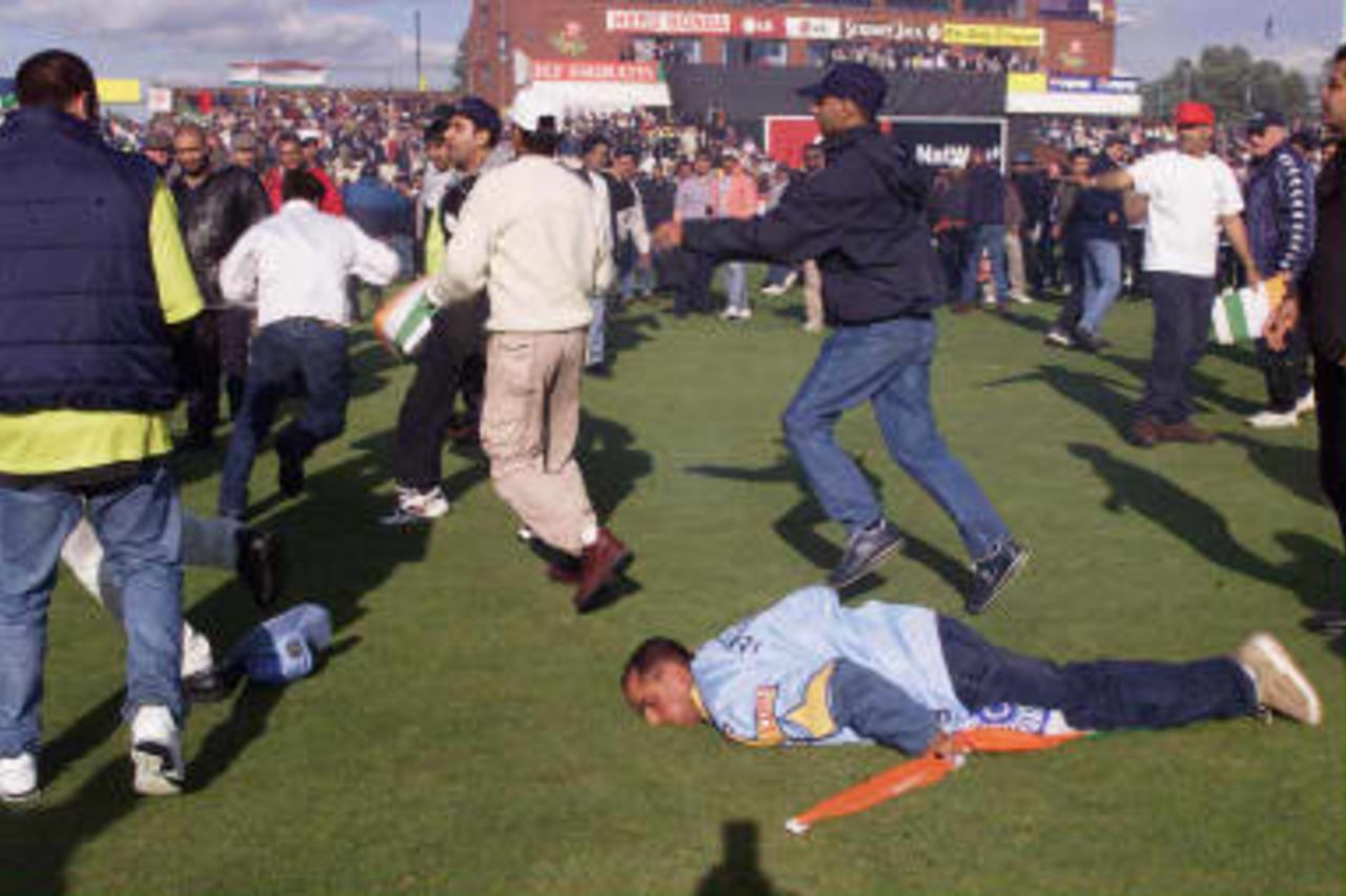 An Indian fan lies unconscious on the ground after being kicked in the head and stamped on after the Indian win over Pakistan in their Super SIx Cricket World Cup match at Old Trafford in Manchester. 08 June 1999.