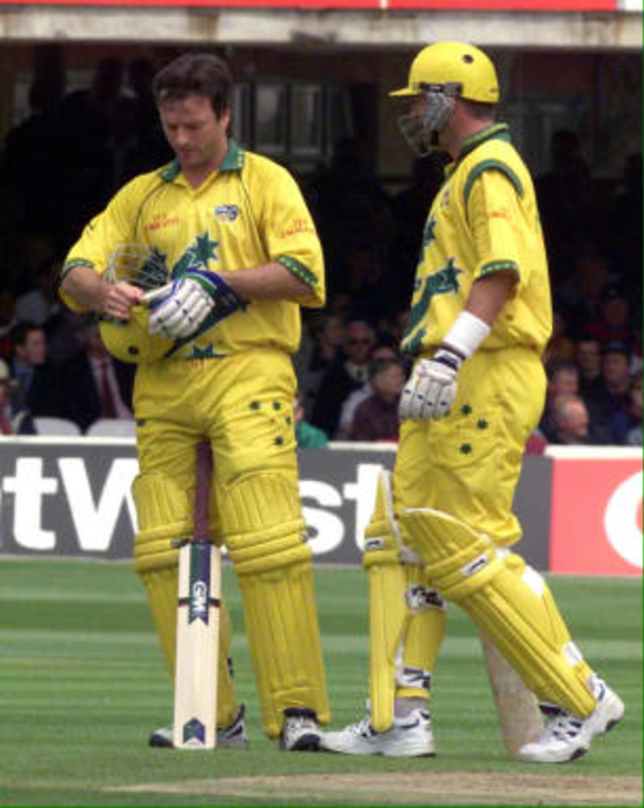 Australia`s captain Steve Waugh checks his helmet after being hit on the head by his brother Mark`s (R) drive during the Australian innings in the match between Zimbabwe v Australia in the Cricket World Cup match at Lords 09 June1999