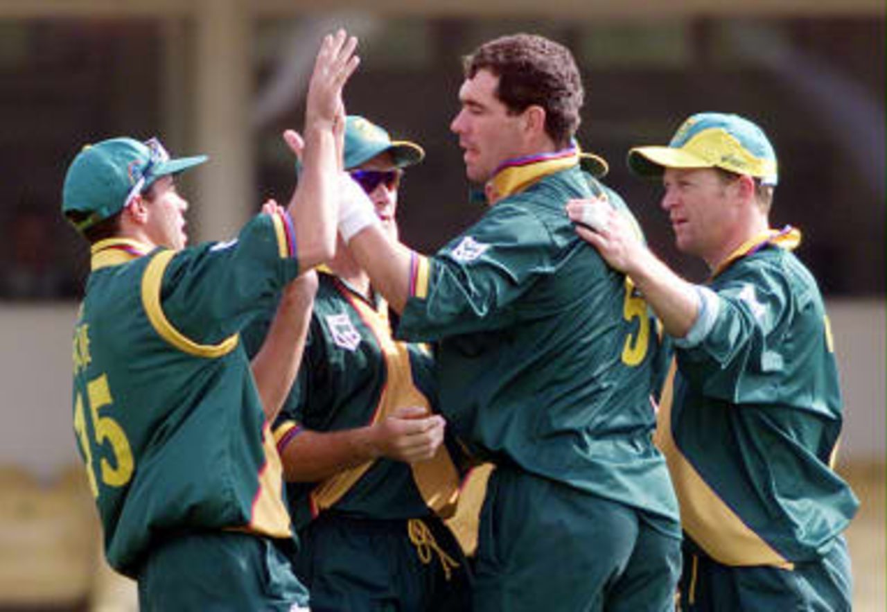 South Africa's captain Hansie Cronje is congratulated by Nicky Boje (L) and Jonty Rhodes (R) after taking the wicket of New Zealand's Craig McMillan 10 June 1999 during their Super Six match in the Cricket World Cup at Edgbaston, Birmingham. The final will be held at Lords 20 June 1999