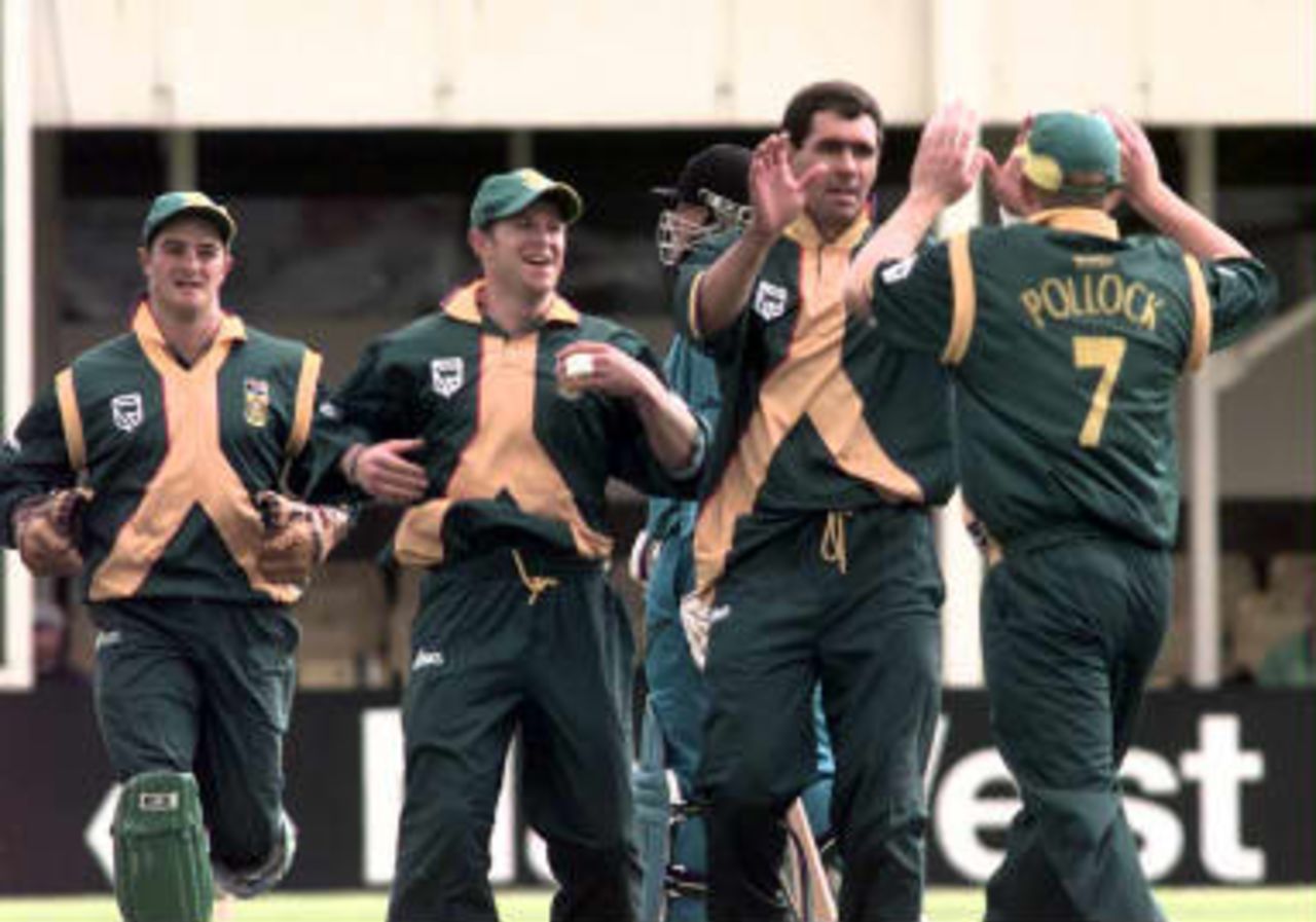South Africa's captain Hansie Cronje (C-R) is congratulated by teammates after taking the wicket of New Zealand captain Stephen Fleming during Cricket World Cup Super Six match at Edgbaston, Birmingham.