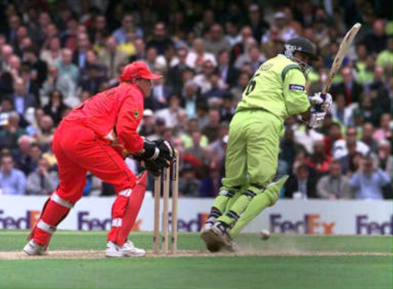 Pakistan opening batsman, Saeed Anwar (R) adds to his runs total as he is watched by Zimbabwe wicketkeeper Andy Flower during their Cricket World Cup Super Six match at The Oval in London 11 June 1999