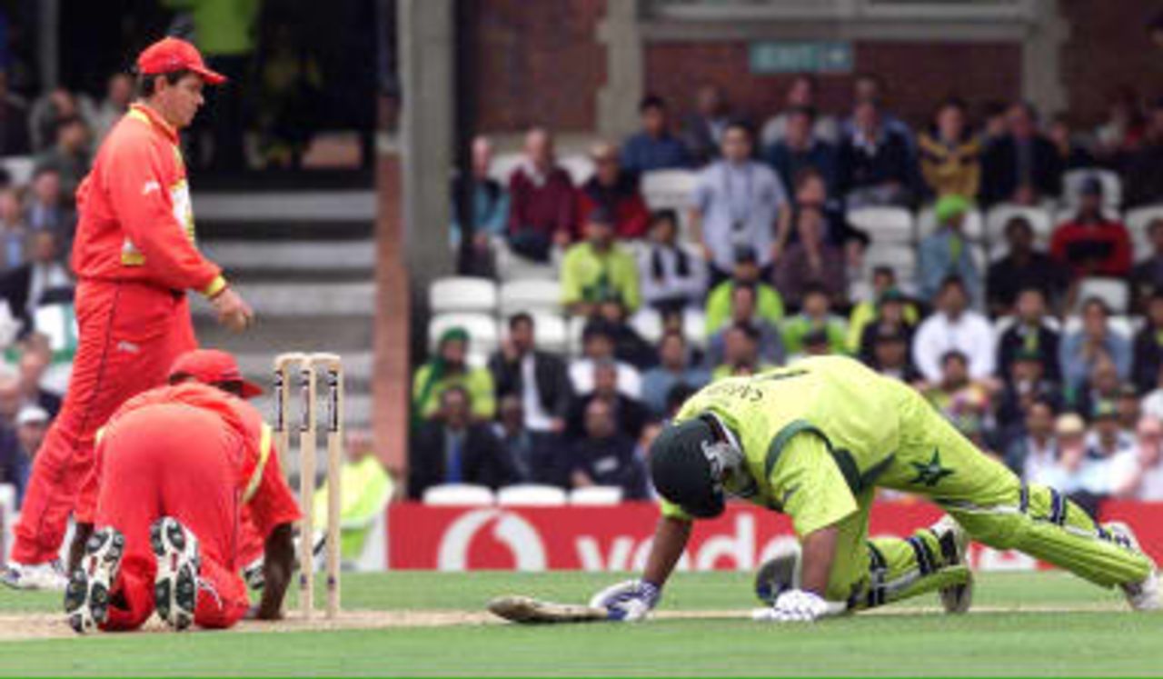 Henry Olonga of Zimbabwe (Left) attempts to run out Pakistan`s Saeed Anwar in the opening stages of the Cricket World Cup match at the Oval in London, 11 June 1999.
