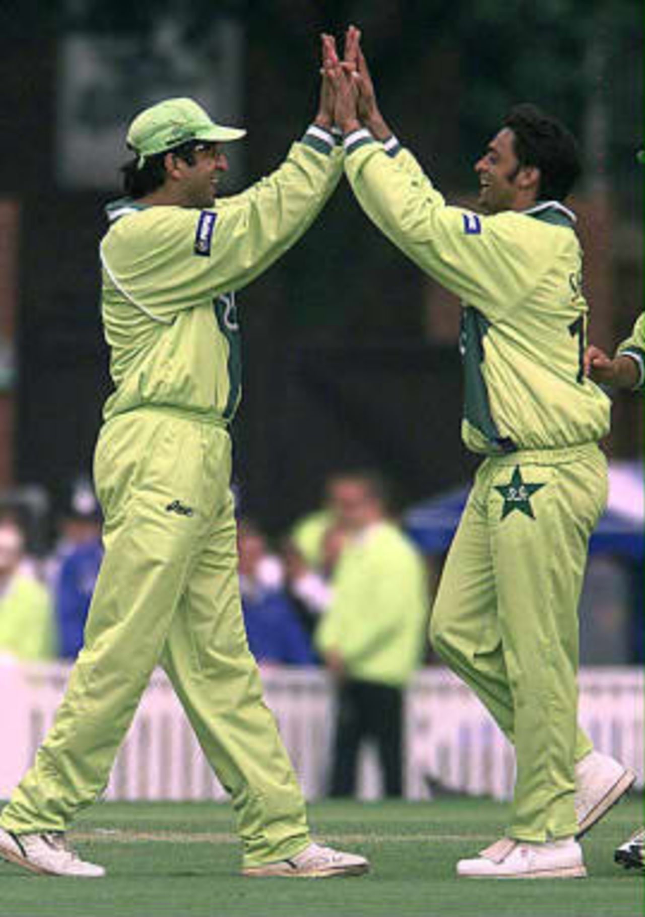 Pakistan captain Wasim Akram, (L) celebrates with teammate Shoaib Akhtar following the dismissal of Zimbabwe captain, Alistair Campbell for three runs caught by Wasim, and bowled by Abdul Razzaq during today's 11th June 1999 Cricket World Cup Super Six match at The Oval, London