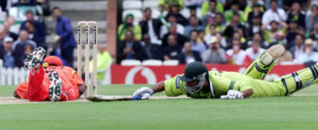 Henry Olonga of Zimbabwe (Left) attempts to run out Pakistan's Saeed Anwar in the opening stages of their Cricket World Cup match at the Oval in London, 11 June 1999.