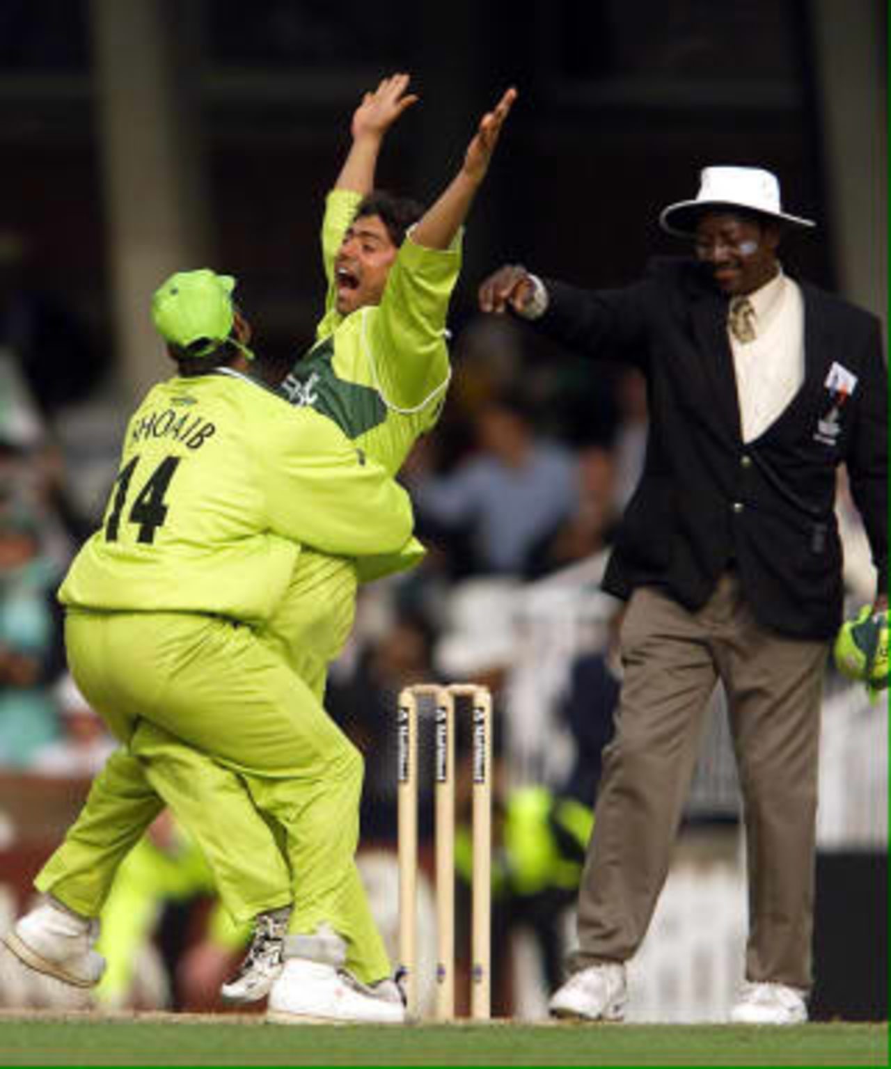 Saqlain Mushtaq (Right) of Pakistan celebrates taking his hat trick as Pakistan beat Zimbabwe at the Cricket World Cup match at the Oval in London, 11 June 1999.
