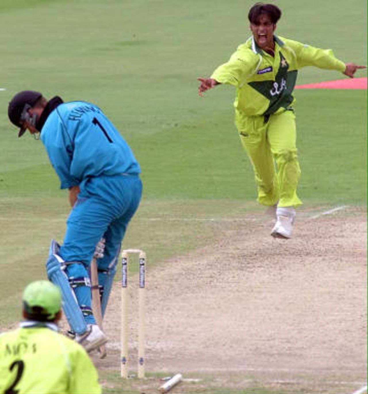 Shoaib Akhtar (R) of Pakistan shows his joy at taking the wicket of Stephen Fleming of New Zealand in their Cricket World Cup semi-final at Old Trafford in Manchester 16 June 1999