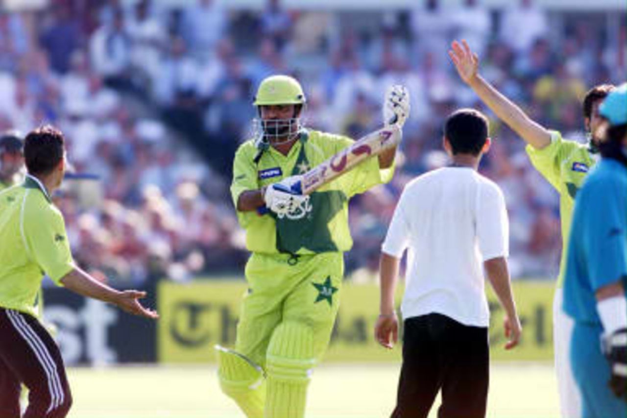 Pakistan's Ijaz Ahmed chases fans from the pitch before the match finished with six runs to go as Pakistan beat New Zealand 16 June 1999 in  semi-final in the Cricket World Cup at Old Trafford, Manchester. The final will be at Lords