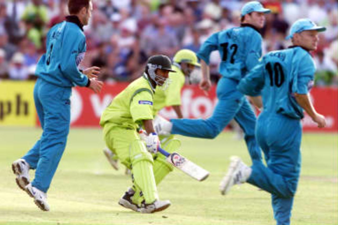 Pakistan's top scorer Saeed Anwar (C) and Ijaz Ahmed complete the final runs in their victory over New Zealand as thousands of Pakistani fans invade the pitch 16 June 1999  after their semi-final match in the Cricket World Cup at Old Trafford, Manchester. The final will be at Lords