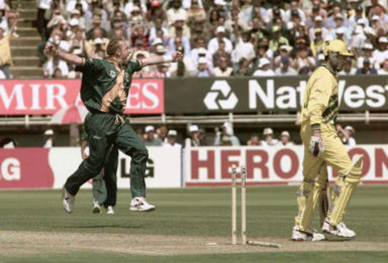 Australian Damien Fleming (R) is bowled for a duck by South African Alan Donald (L) during their match 17 June 1999 at the Cricket World Cup semi-final at Edgbaston in Birmingham