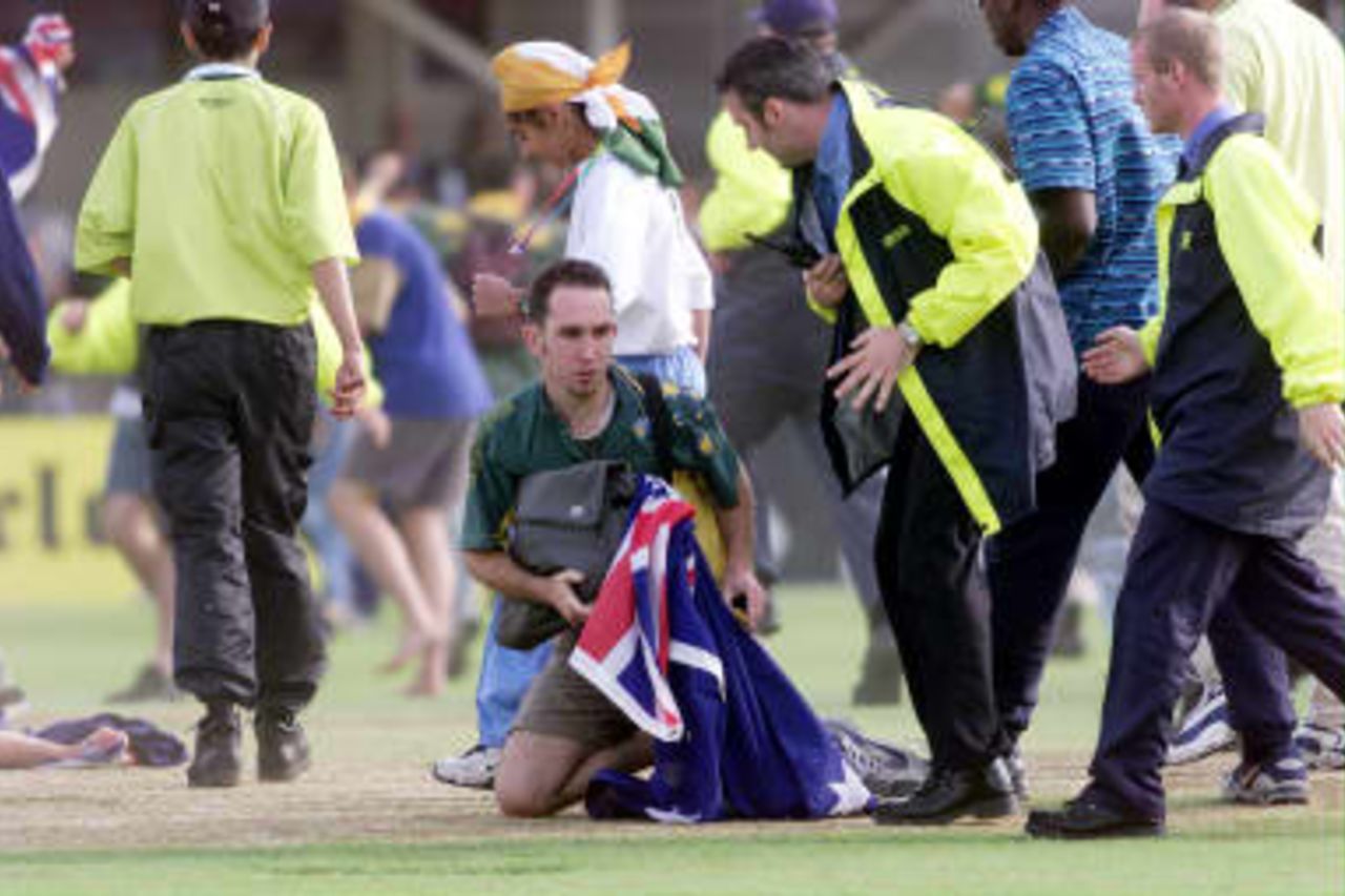 An Australian fan kneels at the crease, as security move in,  where Australia run out Allan Donald in the final over for victory over South Africa during their semi-final match in the Cricket World Cup at Edgbaston, Birmingham, 17 June 1999.