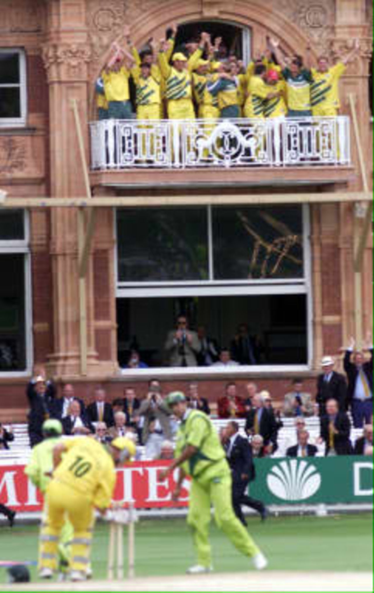 Australia`s cricket team celebrate from their dressing room balcony as the winning runs are scored against Pakistan in the World Cup final at Lords in London, whilst Darren Lehman picks up the wickets. Australia won by eight wickets, 20 June 1999.