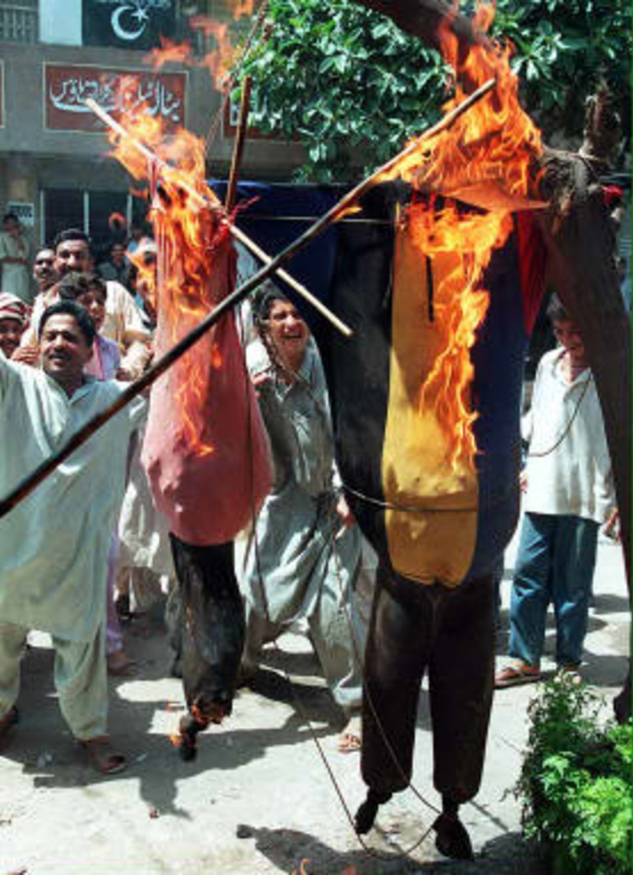 Angry protestors burn effigies of Pakistan cricket team captain Wasim Akram and vice captain Moin Khan in Lahore to express their anger over the humiliating  defeat by Australia in the World Cup final at Lords, in Lahore 22 June 1999.