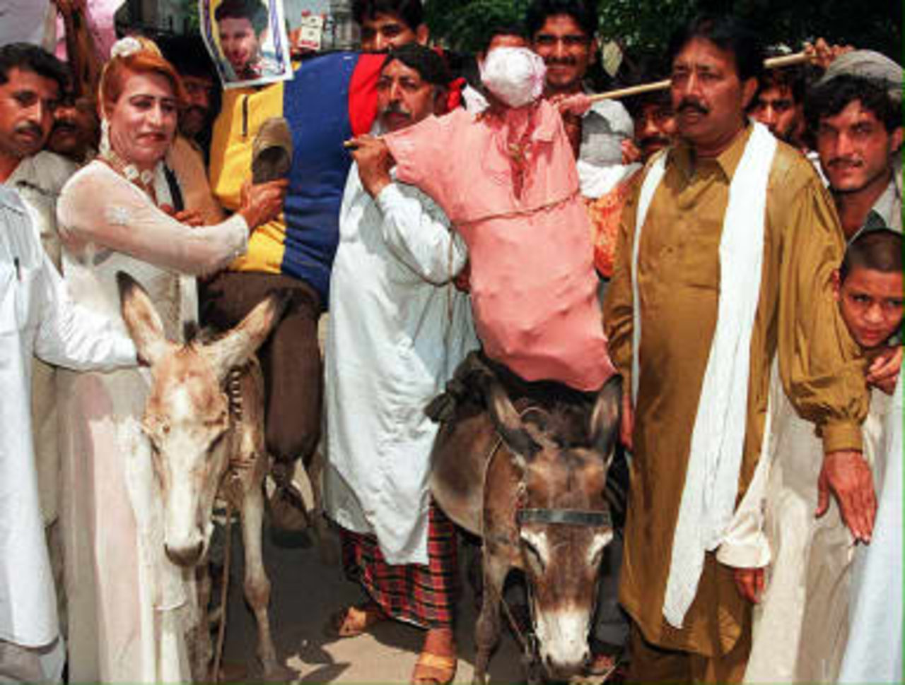 Effigies of Pakistan cricket team captain Wasim Akram and vice captain Moin Khan are given a donkey ride by fans to express their anger over the humiliating defeat by Australia in the World Cup final at Lords, in Lahore 22 June 1999.