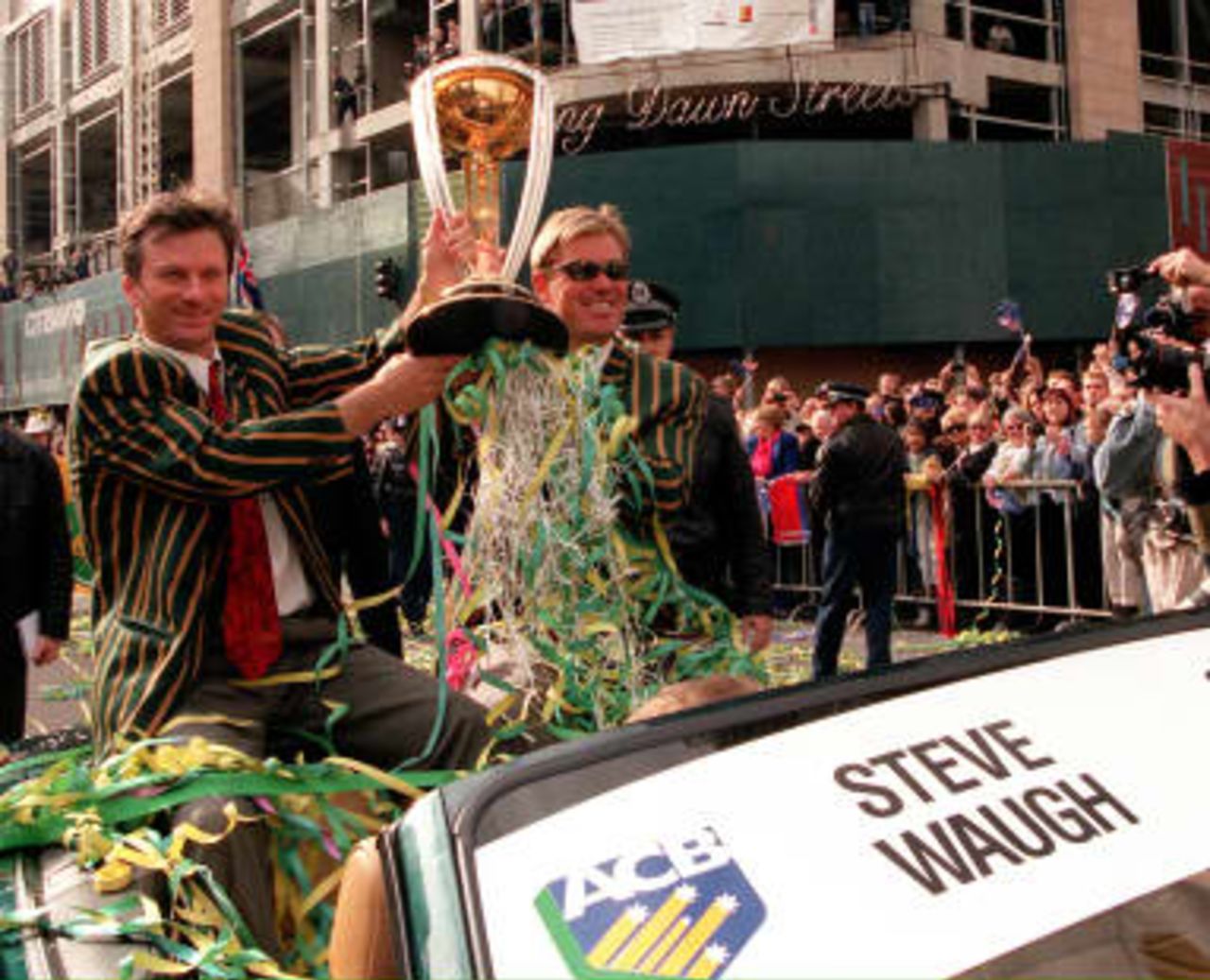 Australian cricket captain Steve Waugh (Left) and vice captain Shane Warne (2nd Left) hold the World Cup trophy during a parade through the streets of Sydney on 28th June 1999. The team was feted by some 100,000 people to mark the World Cup win earlier this month.