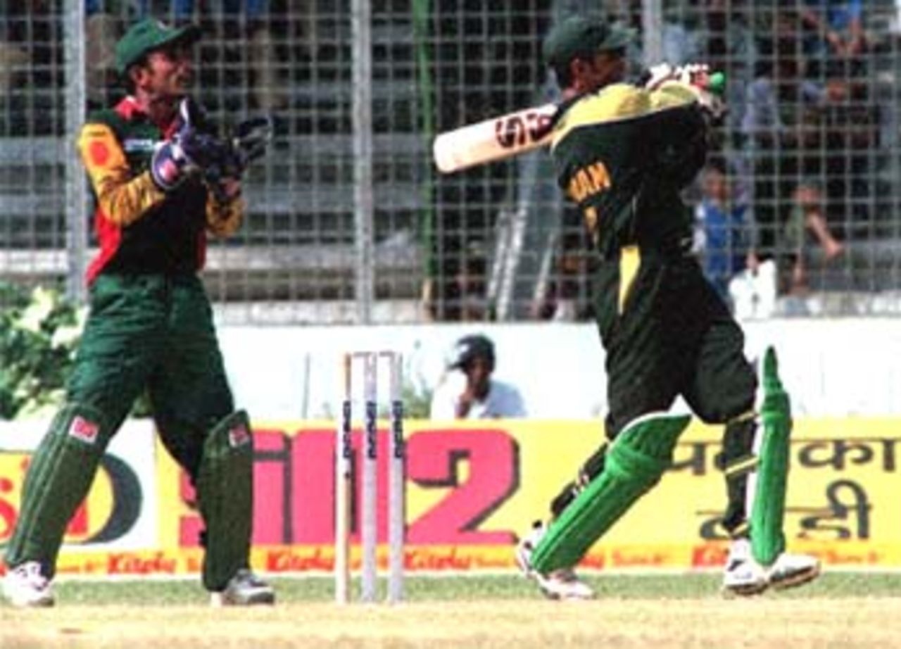 Pakistani opening batsman Imran Nazir strikes one of his master strokes to score 80 runs off 76 balls during the fourth match of the four-nation Asia Cup limited-overs tournament in Dhaka. At (L) is Bangladesh wicketkeeper Khaled Mashud. Pakistan ploughed through the relatively weak bowling and fielding of hosts Bangladesh and piled up a huge score of 320-3 in 50 overs. Asia Cup, 1999/00, 4th Match, Bangladesh v Pakistan, Bangabandhu National Stadium, Dhaka, 02 June 2000.