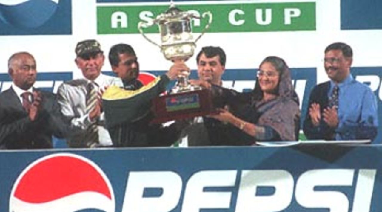 Pakistani captain Moin Khan (3rd L) receives the seventh Asia Cup trophy from Bangladeshi Prime Minister Sheikh Hasina Wajed (2nd R) after Pakistan beat defending champion Sri Lanka by 39 runs in an exciting final match of the limited-overs tournament, 07 June 2000 in Dhaka. Pakistan, which won all the earlier league matches it played against India, Sri Lanka and host Bangladesh, clinched the Asia Cup for the first time since its introduction in 1986. Also in the picture are Bangldeshi State Minister for Sports Obaildul Quader (R), Bangladesh Cricket Board Chairman Saber Hossain Chowdhury (3rd R) and other unidentified officials and sponsors.