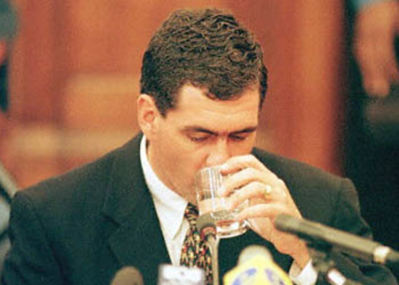 Former South African cricket captain Hansie Cronje drinks a glass of water whilst giving his testimony at the King Commission of Inquiry into allegations of cricket match-fixing in Cape Town 15 June 2000.