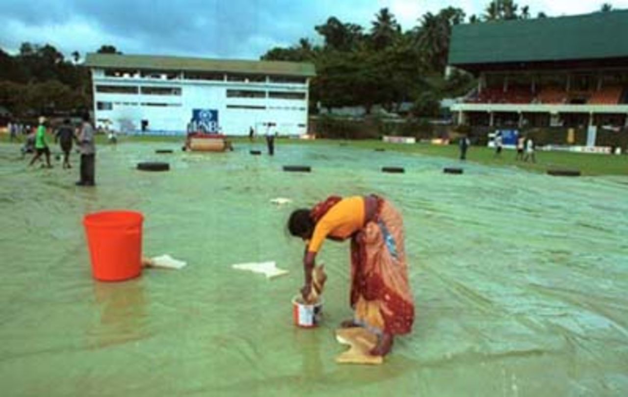 Ground staff collect water from the covers during the third day of the third cricket Test between Sri Lanka and Pakistan in Asgiriya International cricket stadium in Kandy, Sri Lanka on Friday, June. 30, 2000