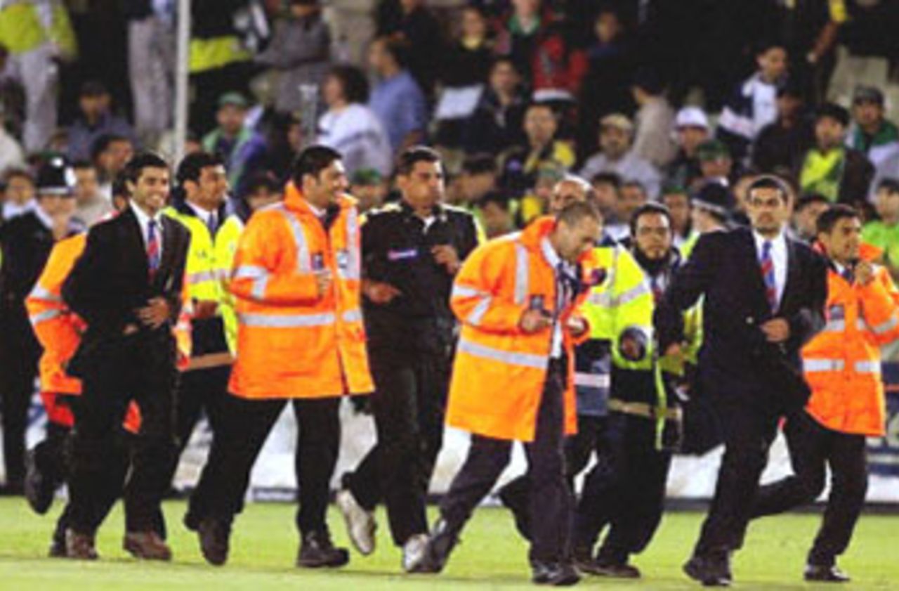 Waqar Younis is surrounded by security after pleading to the Pakistani fans not to invade the pitch, 1st ODI at Edgbaston, 7 June 2001.