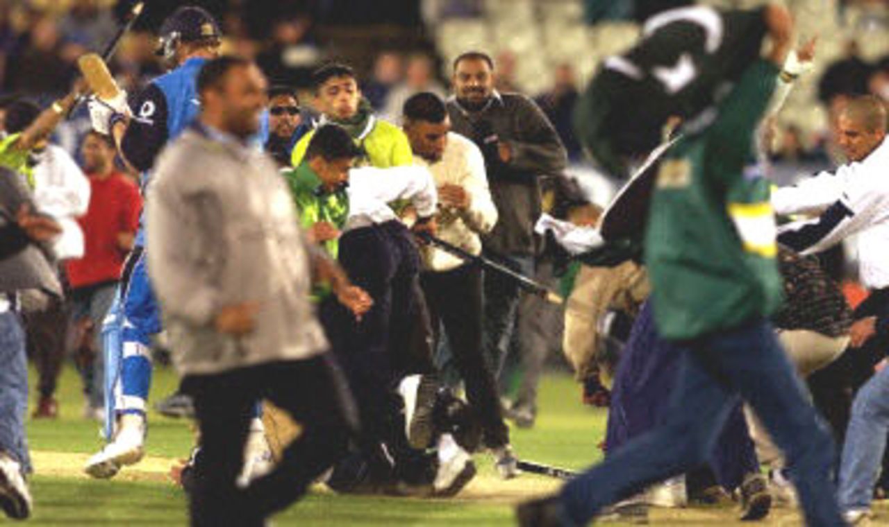 Alan Mullally is swamped by hundreds of Pakistan supporters who invaded the pitch and stole the wickets, 1st ODI at Edgbaston, 7 June 2001.