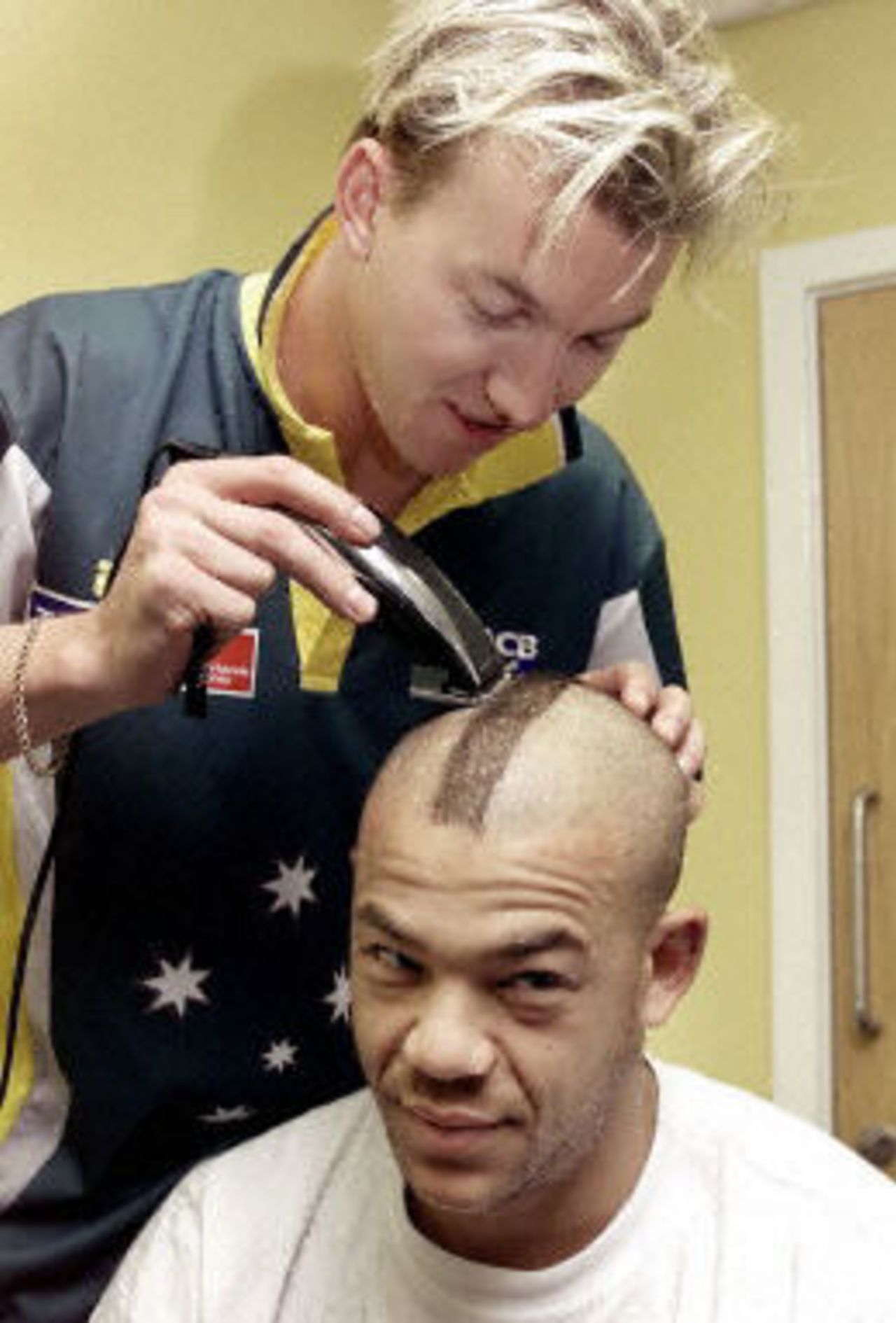 Australian fast bowler Brett Lee gives Andrew Symonds a Mohawk haircut made famous by the Manchester United soccer player David Beckham as rain delays the start of Australia's match against Pakistan, 6th ODI at Chester-le-Street, 16 June 2001.