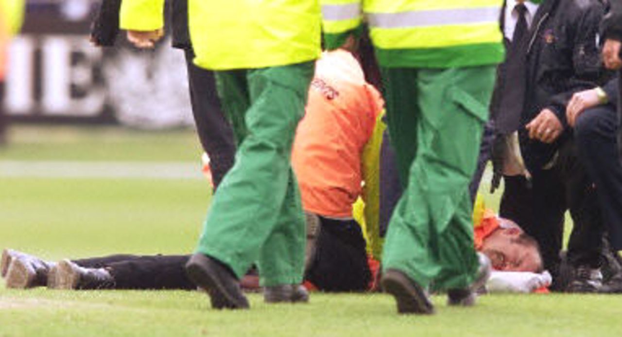 An injured marshall lies in pain on the ground after been hurt in the pitch invasion, 7th ODI at Headingley, 17 June 2001.