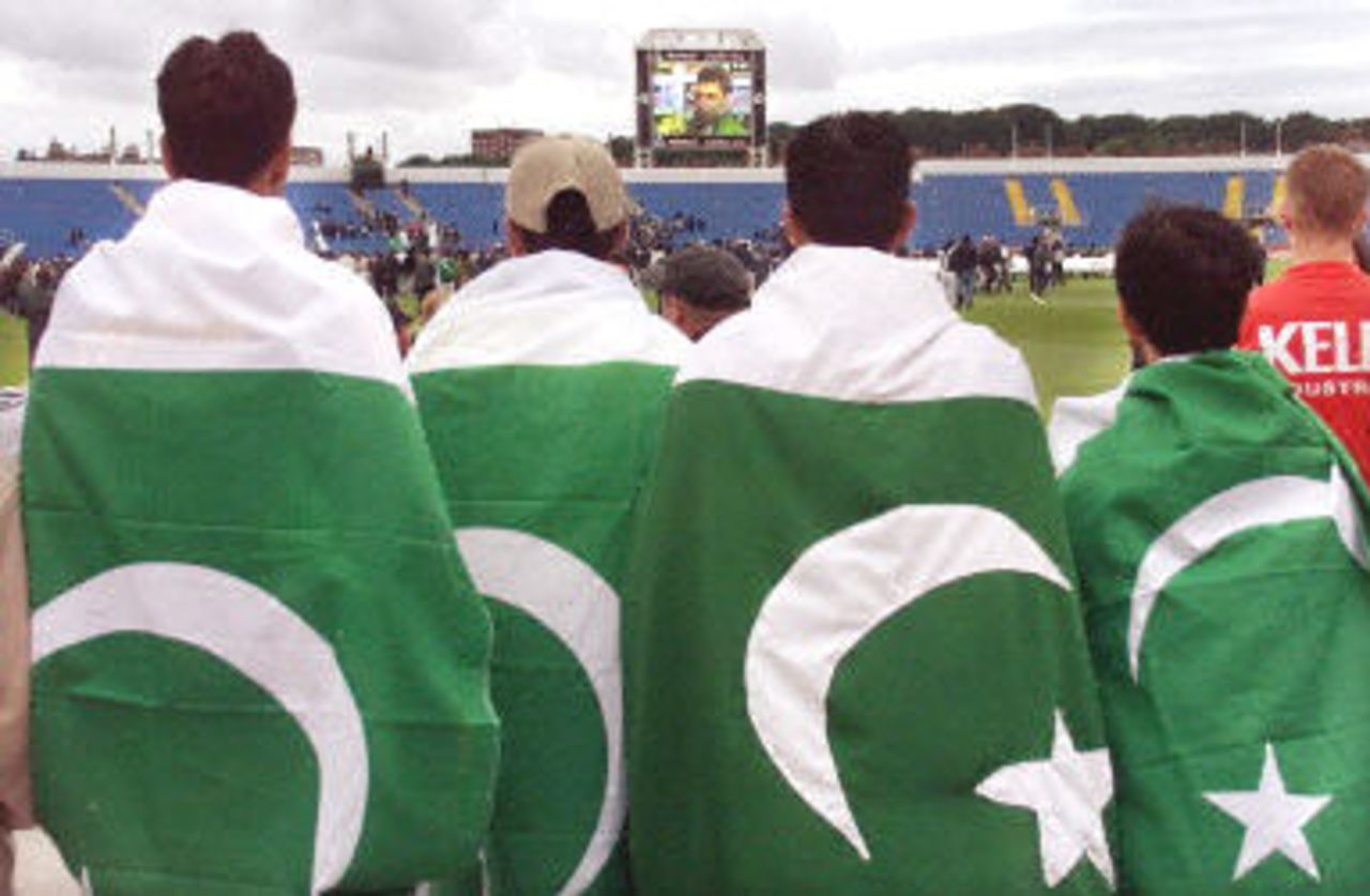 Pakistani fans watch their captain Waqar Younis on the giant screen reflect sadly on the pitch invasion, 7th ODI at Headingley, 17 June 2001.