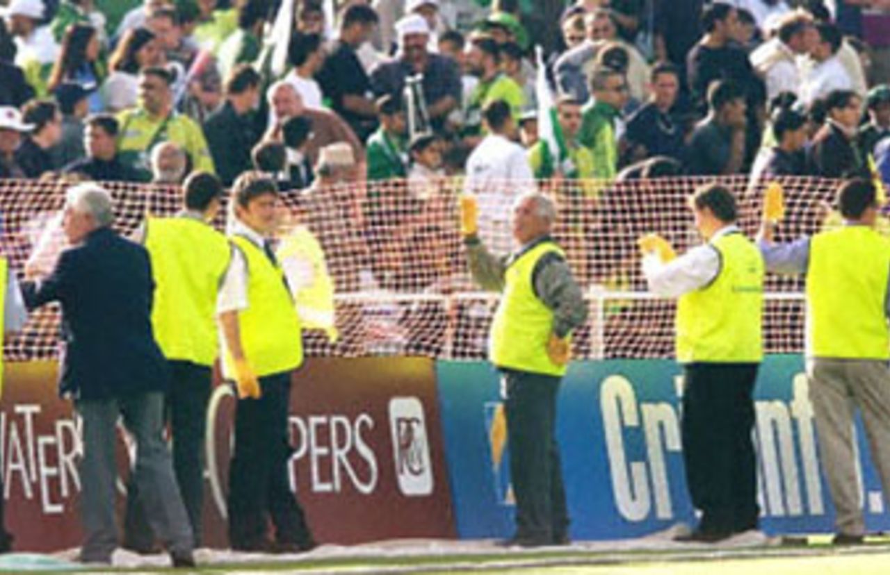 Stewards hold up netting to prevent Pakistani fans entering the field after Steve Waugh leads his team off the field, 8th ODI at Trent Bridge, 19 June 2001.