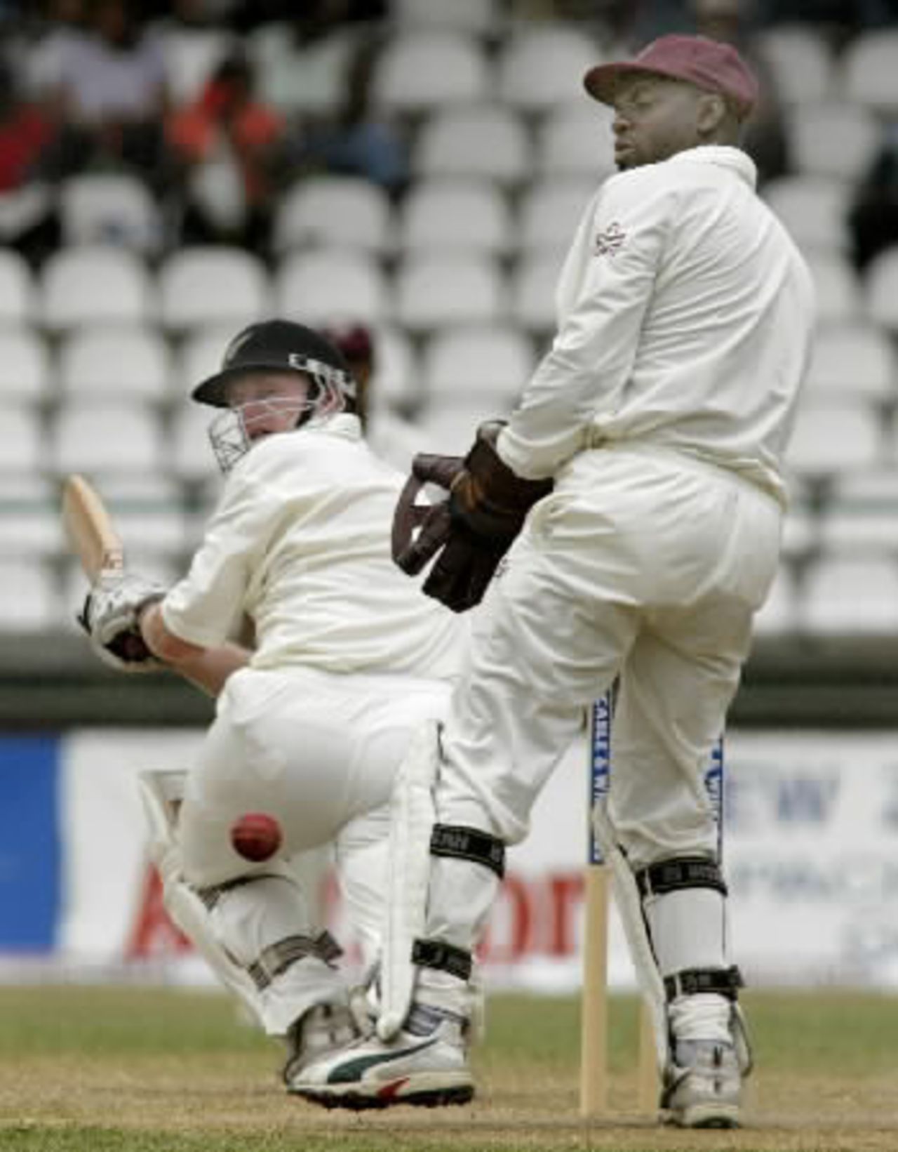New Zealand batsman Scott Styris sweeps a delivery from West Indies bowler Mahendra Nagamootoo to the boundary during his first innings of 107 as wicket-keeper Ridley Jacobs looks on. 2nd Test: West Indies v New Zealand at Queen's Park, St George's, Grenada, 28 June-2 July 2002 (29 June 2002).