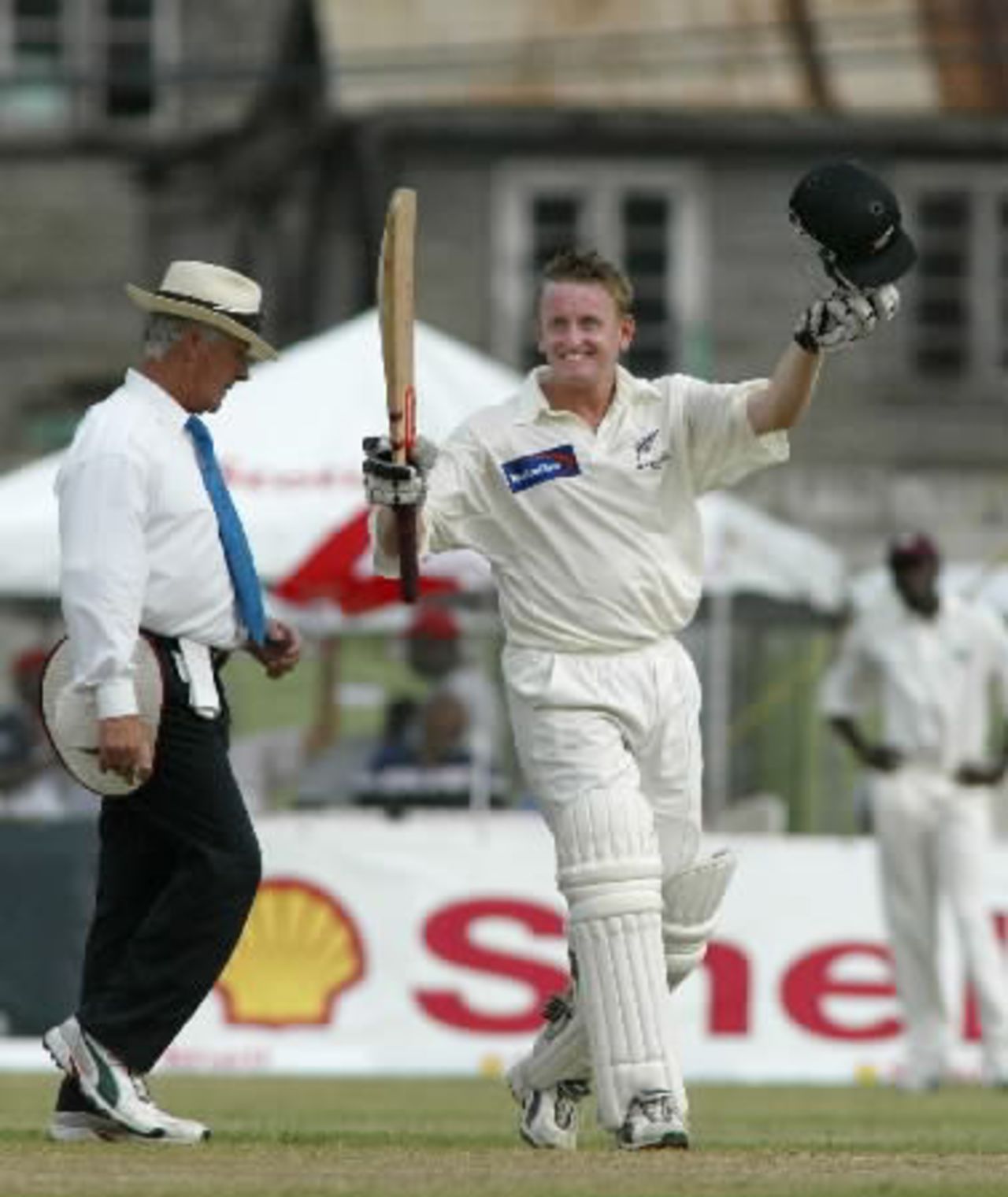 New Zealand batsman Scott Styris raises his bat and helmet to celebrate reaching his century on debut. Styris went on to score 107 in his first innings. 2nd Test: West Indies v New Zealand at Queen's Park, St George's, Grenada, 28 June-2 July 2002 (29 June 2002).
