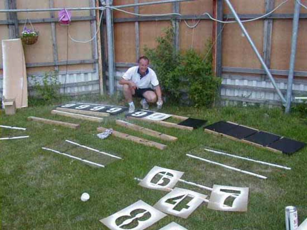 Walter Blaschke gets busy with the spray can and stencils - painting the numbers for Concordia CC's new scoreboard