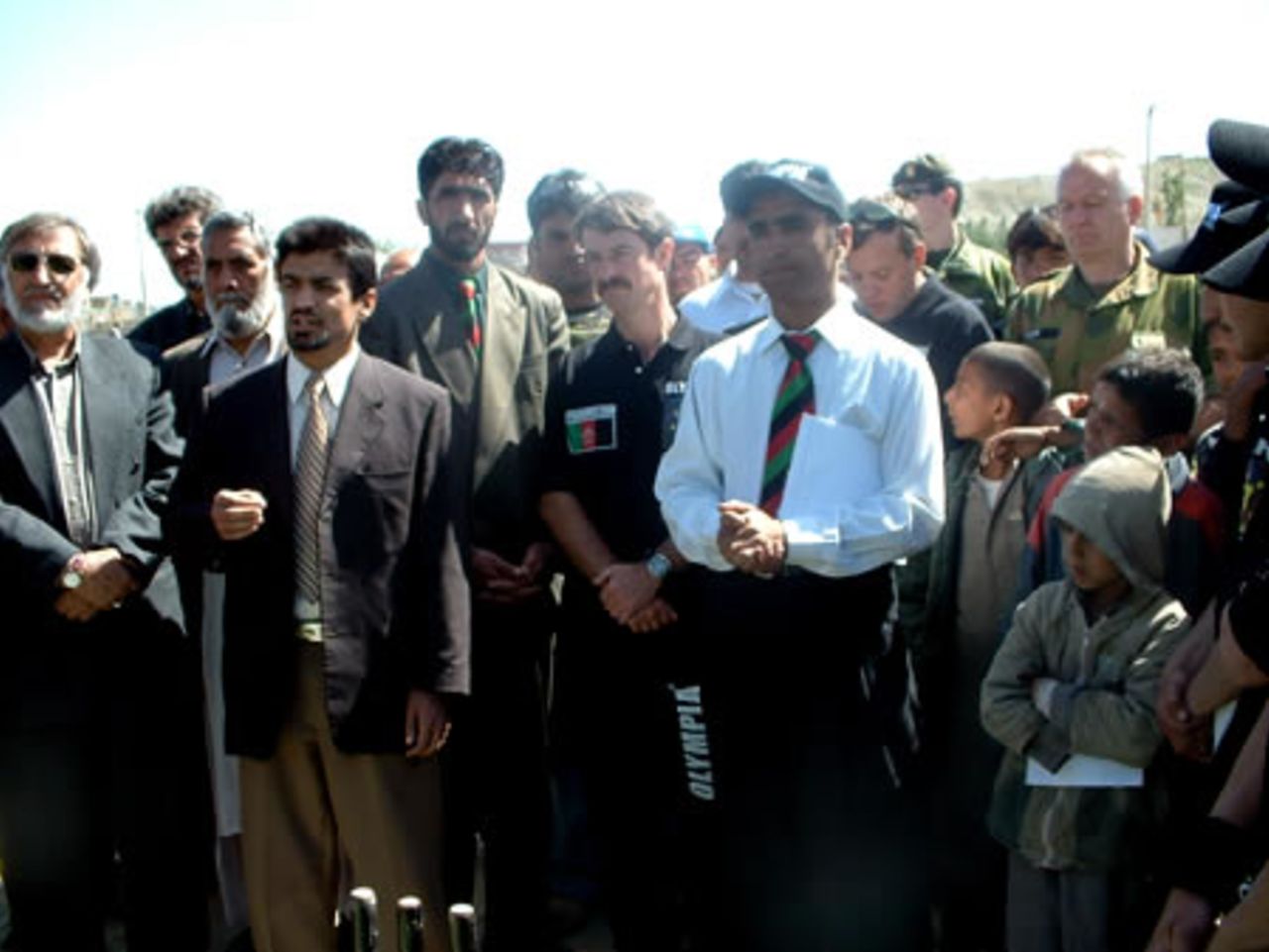 Inauguration ceremony of the first Olympia Lube Oil Cricket Tournament held in Kabul, 5 - 20 May 2003. 14 teams from all over Afghanistan particpated. ACF vice-president Taj Malik (centre, white shirt), to his right Col Tim Betin ISAF, to his right Allah Dad Noori, ACF President, to his right Mr Dashti vice-president Afhgan National Sports Committee, players and guests.