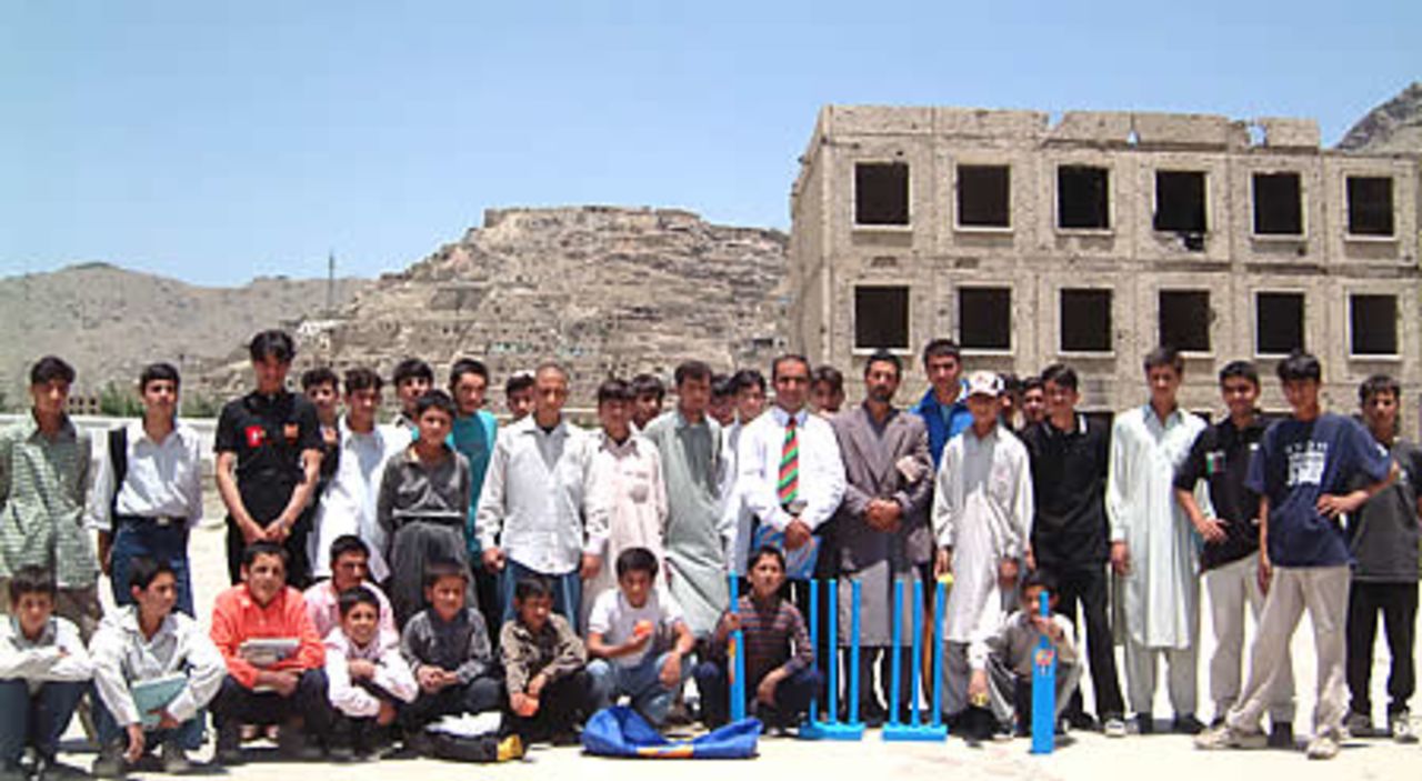Taj Malik, Afghan National coach (white shirt and tie) with Abdul Khalil GM ACF and Khaliq Dad Noori Director Kabul Cricket Association along with students and staff of Habibia High School receiving Kwik cricket set donated by ECB.